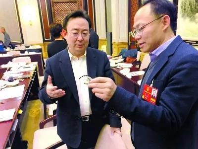 昨天,北京團(tuán)小組會(huì)休息的間隙,程京代表(右)向夏林茂代表介紹基因芯片。張宇攝
